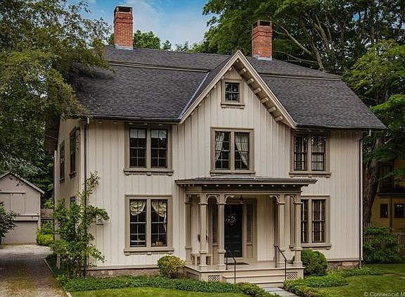 Detail includes distinctive board and batten siding, double windows, copper gutters