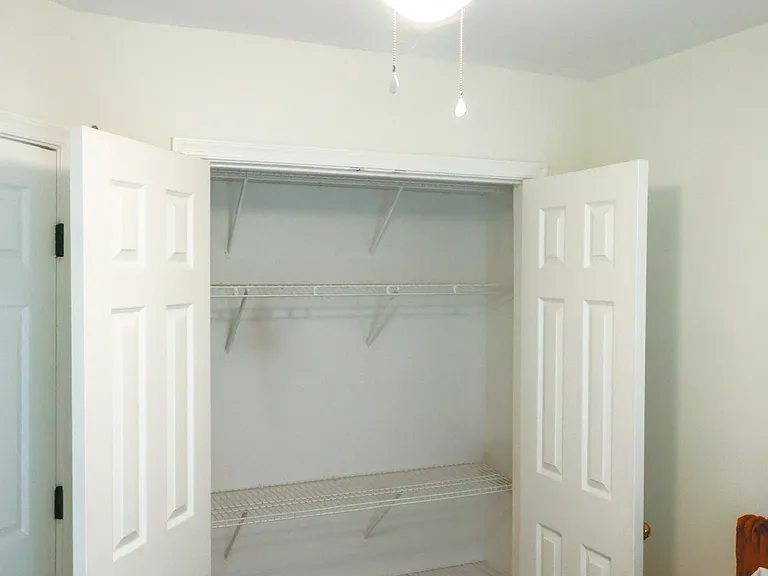Bright bedroom featuring a professionally mounted smart TV with 4K Firestick and a hydraulic lift bed offering generous under-bed storage.
