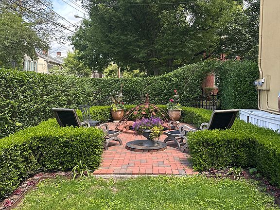 Second private outdoor seating area by the lily pond with a built-in fire pit in the brick patio