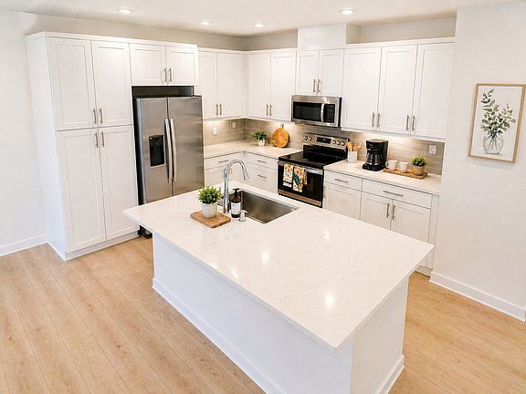 Gourmet kitchen with sleek white cabinetry, Calacatta quartz countertops, stainless steel appliances, and a large center island.