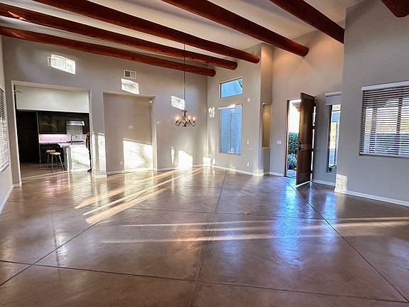 Great room with lots of light, beamed ceilings, gas fireplace, and rear patio access