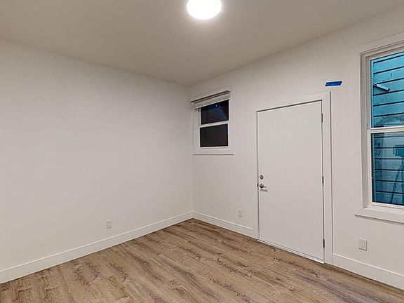Bedroom with a wood-like flooring and large window