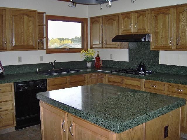Large kitchen has an island and counters of granite composite-more sanitary.