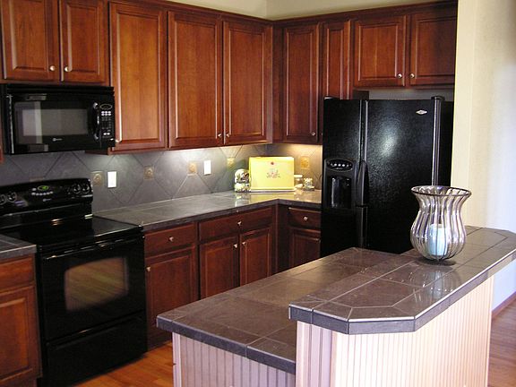 2-tiered island for extra seating finished w/Wainscoting. Under cab. lighting.