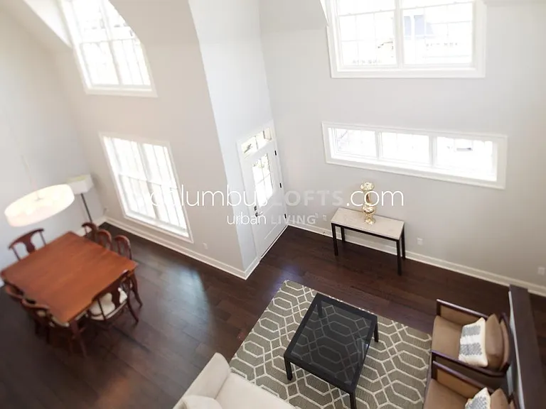 view from upper level hallway overlooking living and dining room