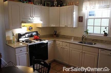 Kitchen : Granite counter tops, terra cotta tiled floor, ample cabinets & deep sink.