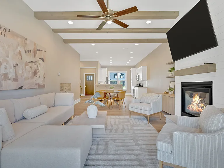 Open-concept living with high ceilings, wide-plank flooring, and gas fireplace
