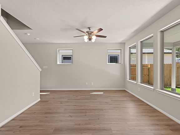 Gather the family and friends in your inviting living room featuring gorgeous floors, a ceiling fan