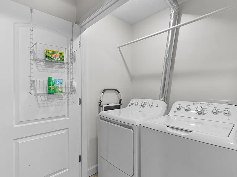 Laundry area has a washer, dryer, iron and ironing board.