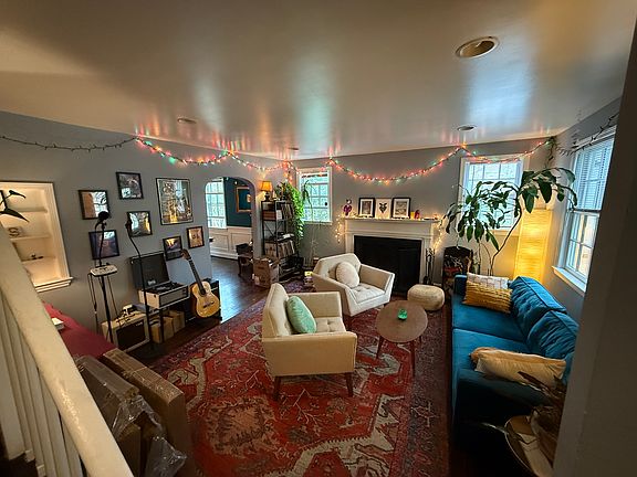 Living room with working fireplace and open doorway into dining room (FYI, some of the furniture may be available for sale by current tenant)
