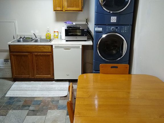 Kitchen dishwasher, sink, dining table, washer and dryer.