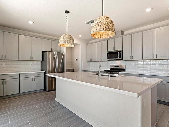 Large, light kitchen with island and upgraded lighting fixtures