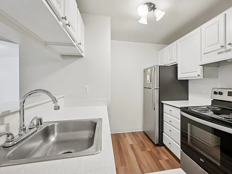 Classic Package III kitchen with stainless steel appliances, white cabinetry, laminate countertops, and hard surface flooring