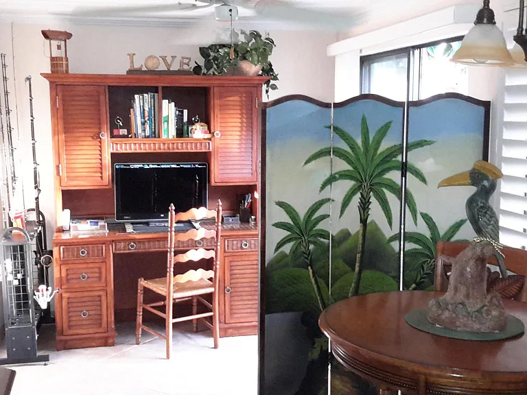 SINGLE-STORY COTTAGE DINING AGEA AND OFFICE AMORE WITH SLIDING GLASS PATIO DOORS OUT TO PRIVATE GIANT DECK