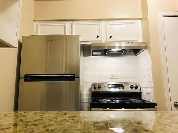 Subway tile backsplash, stainless steel appliances, and refinished cabinets in the kitchen.