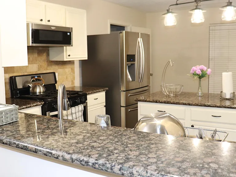 Kitchen with granite counters, breakfast bar, stainless steel appliances, and ample cabinet storage for everyday cooking.