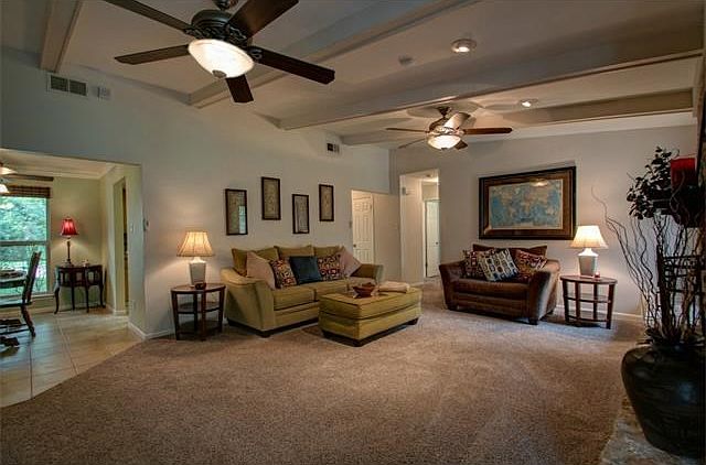 Living area features beamed ceiling and dual ceiling fans