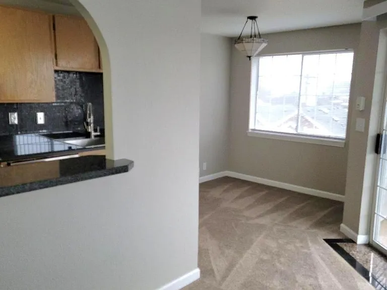 Roman Archway with Granite Bar Top Between Kitchen and Living Room Area