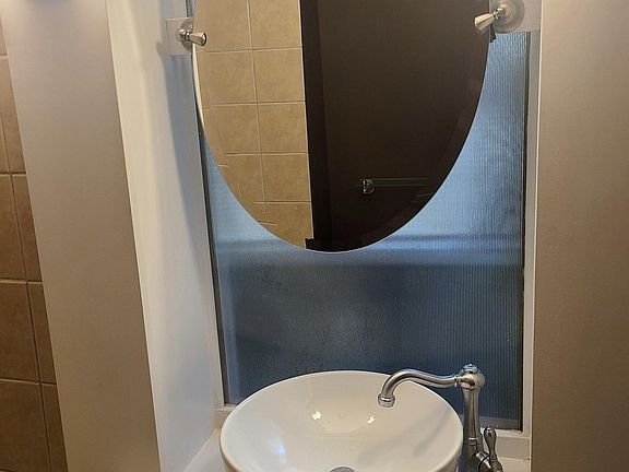 Bathroom with custom glass behind mirror/natural light