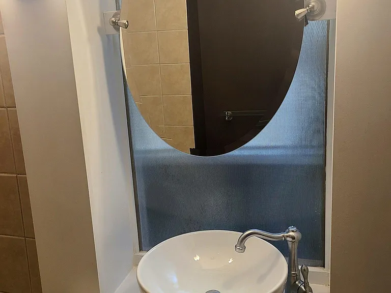 Bathroom with custom glass behind mirror/natural light