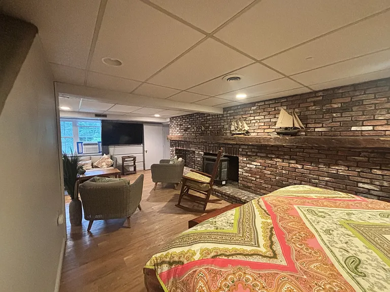 In Law apt open living area with a bed, seating and tv.