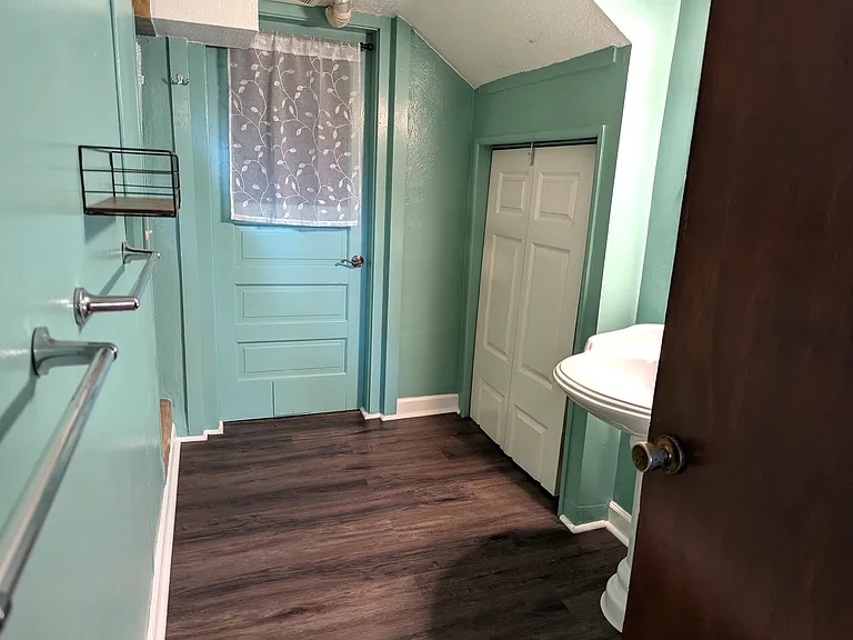 Bathroom with storage closet. Behind the door with the white curtain is the laundry.