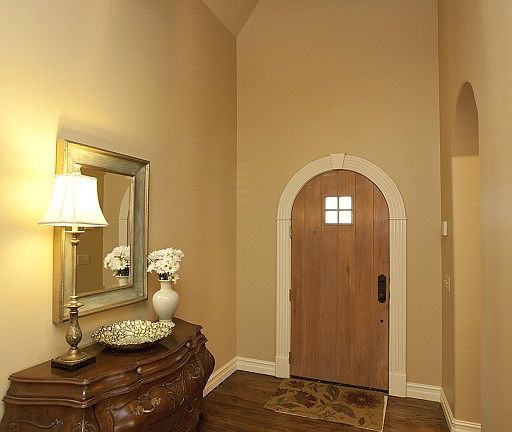 Soaring entry with arched wood door