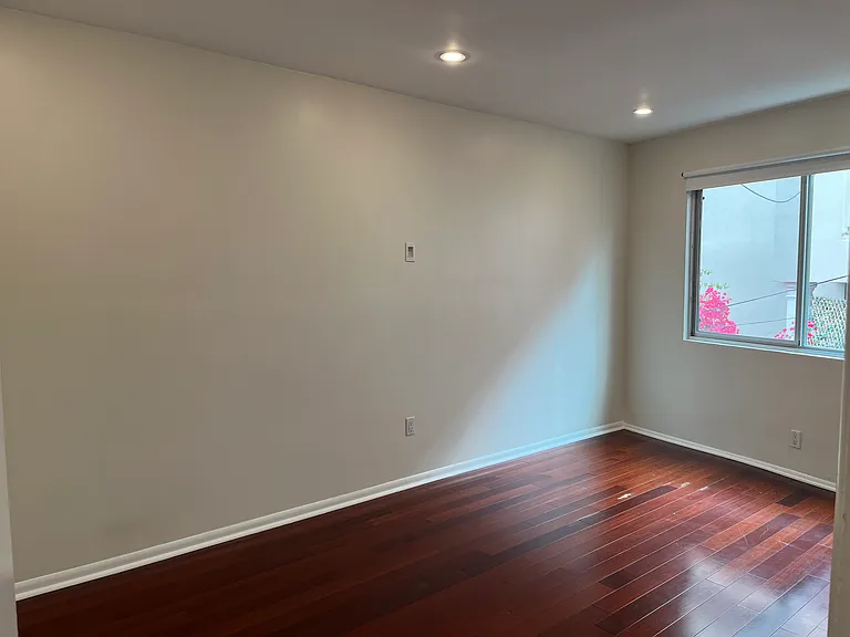 Expansive bedroom with large window, lots of light