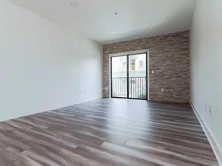 Living room with stone accent wall and view of balcony.