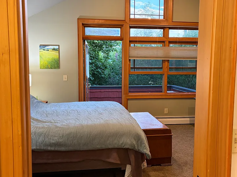 Upper floor primary bedroom with balcony.
