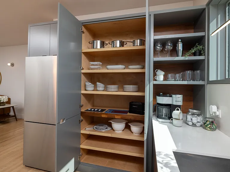 Compact kitchen fully stocked with all essentials and sleek stainless steel appliances_everything you need in a cozy space.
