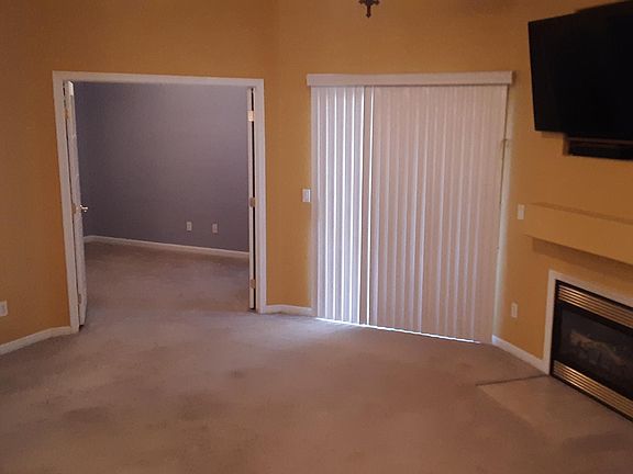 Front room with gas fireplace and patio slider.