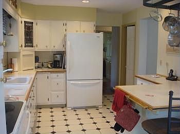 Kitchen with lots of cabinet space, countertops, breakfast bar and tiled flooring.