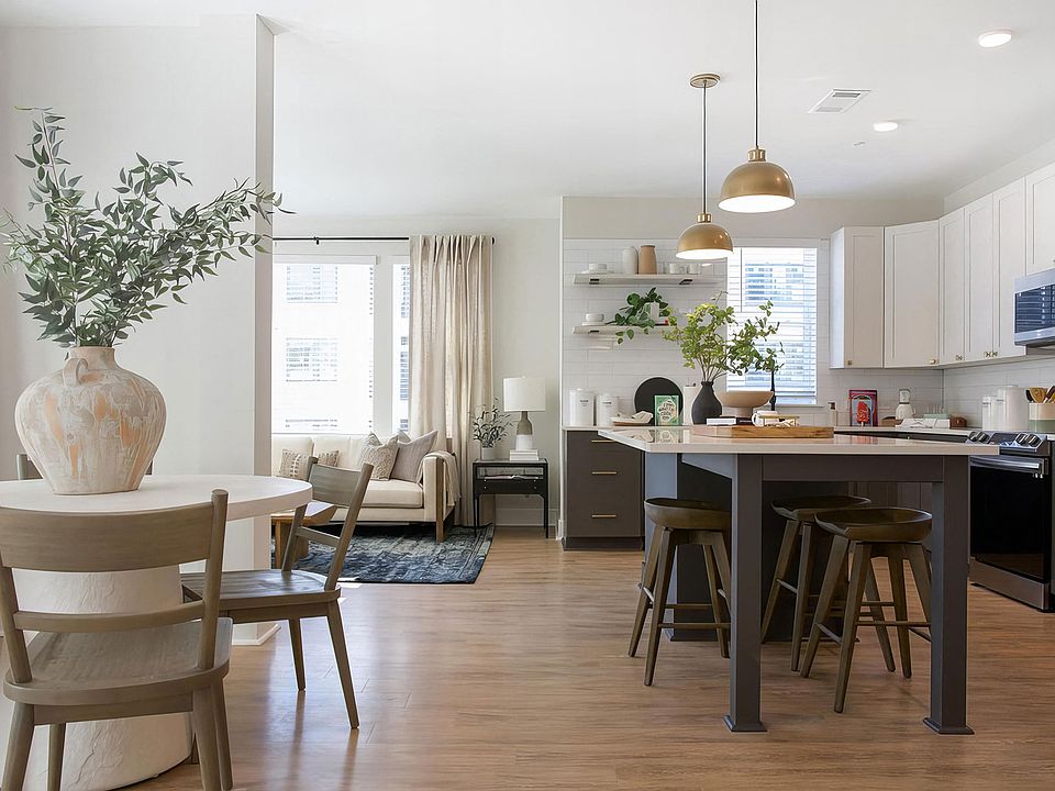 Picturesque open kitchen area with modern island and charcoal color cabinets