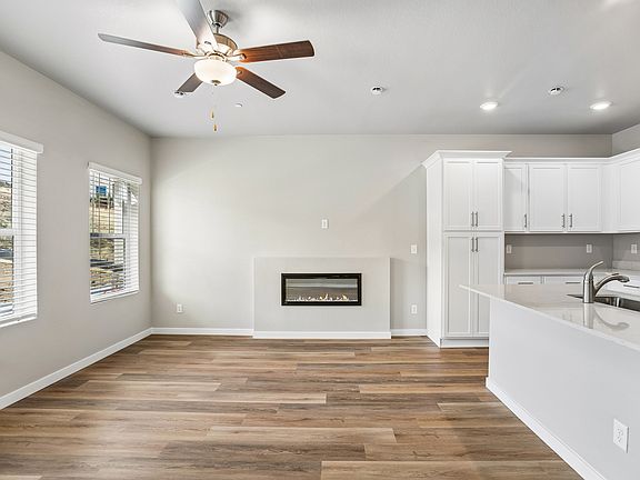 The family room is spacious with a ceiling fan and electric fireplace.