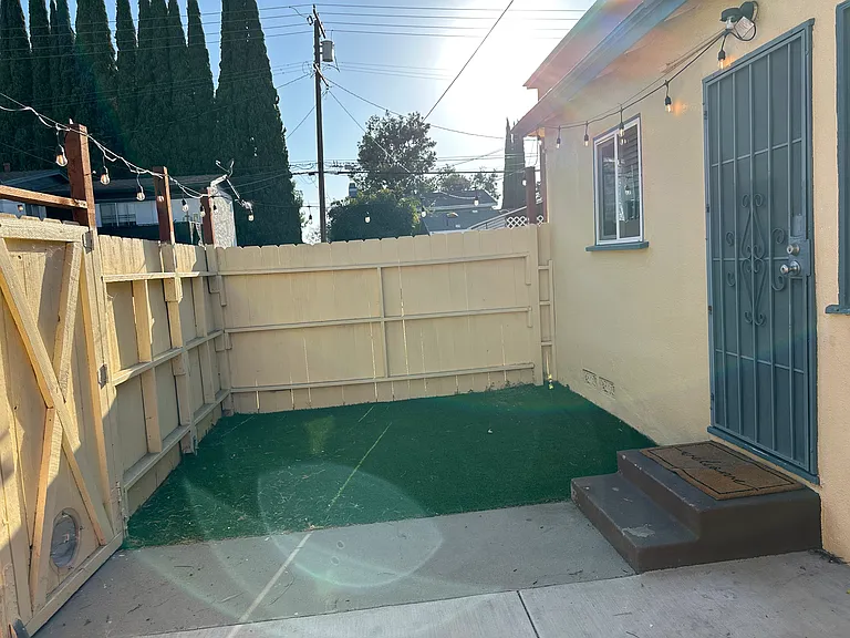 Private patio and yard with artificial grass.
