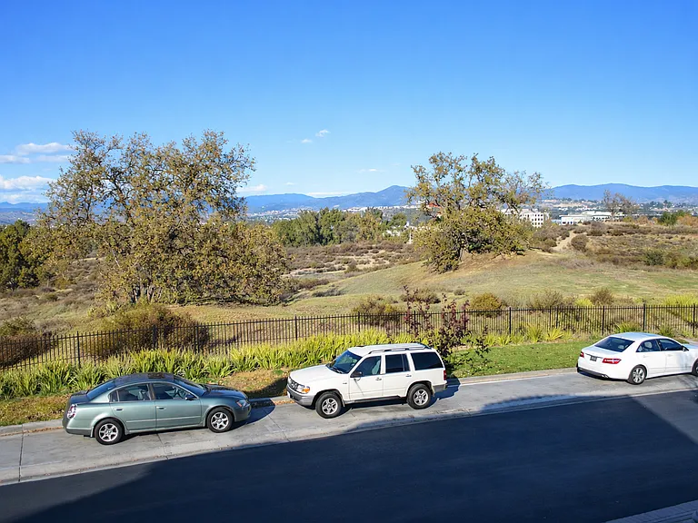 Panoramic view from private master bedroom balcony overlooking open landscape (private gated park below and view of golf course and Valencia town center)