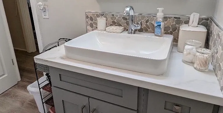 Bathroom sink, large medicine cabinet above sink not shown. Door to left is bedroom, straight out is living room, & out bathroom door to the right is opposite entrance to the kitchen.