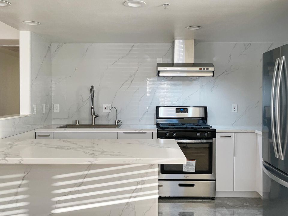 Brand new kitchen with stainless steel appliances and quartz finishes
