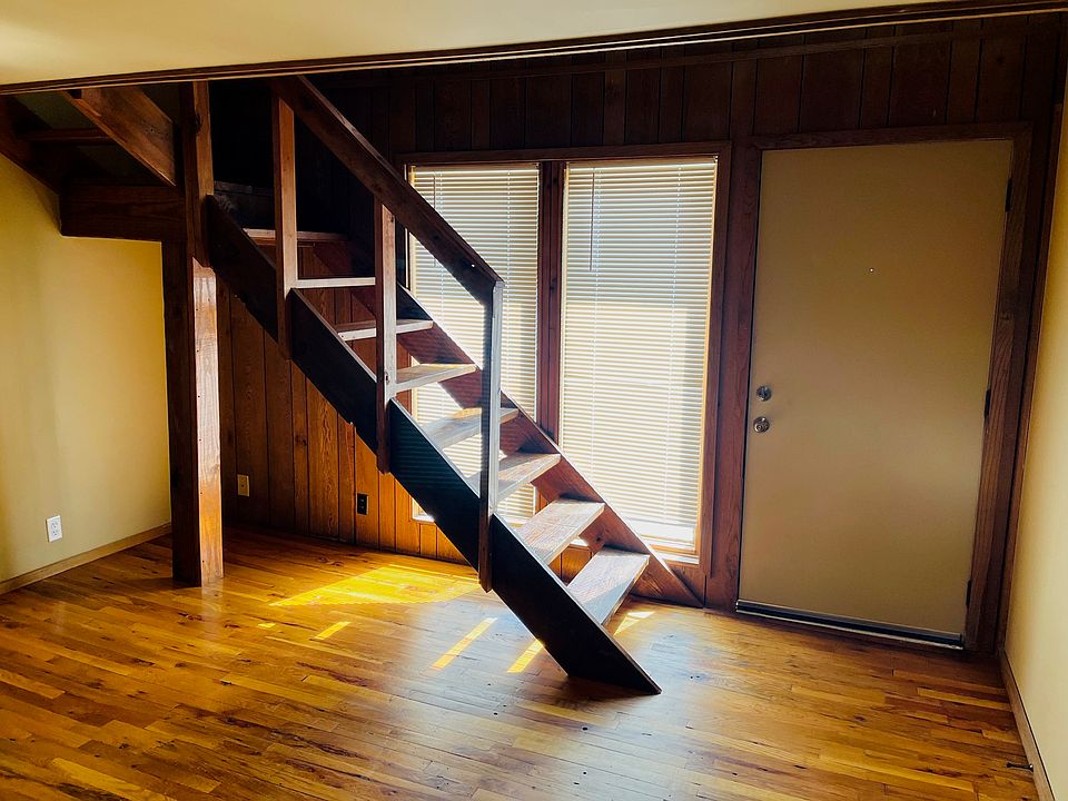 Main entrance, first floor living area, and stairway that leads to upstairs living area, bedroom, and bathroom.