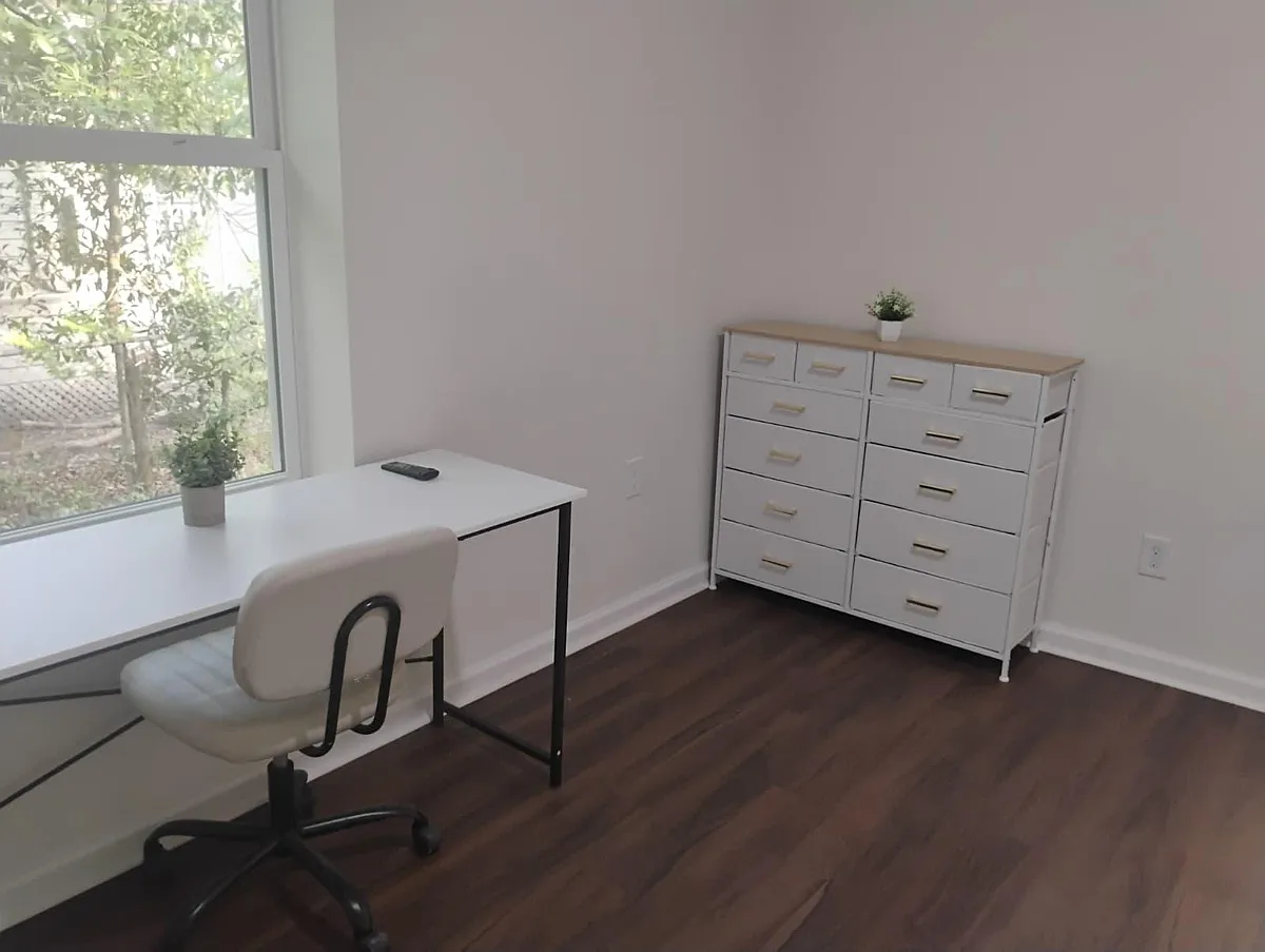 Dedicated workspace nook with a large window, desk and chair, plus a multi-drawer dresser for convenient storage. - Christobel Ave