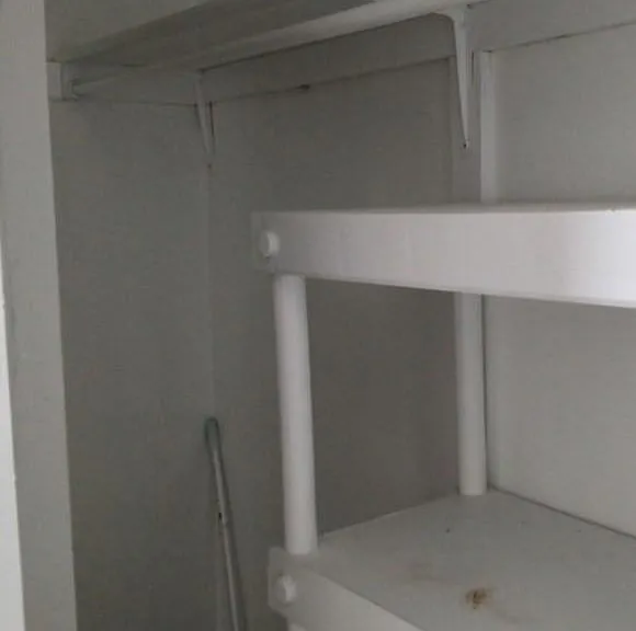 Dedicated storage closet with built-in shelving for pantry items, linens, or household supplies.