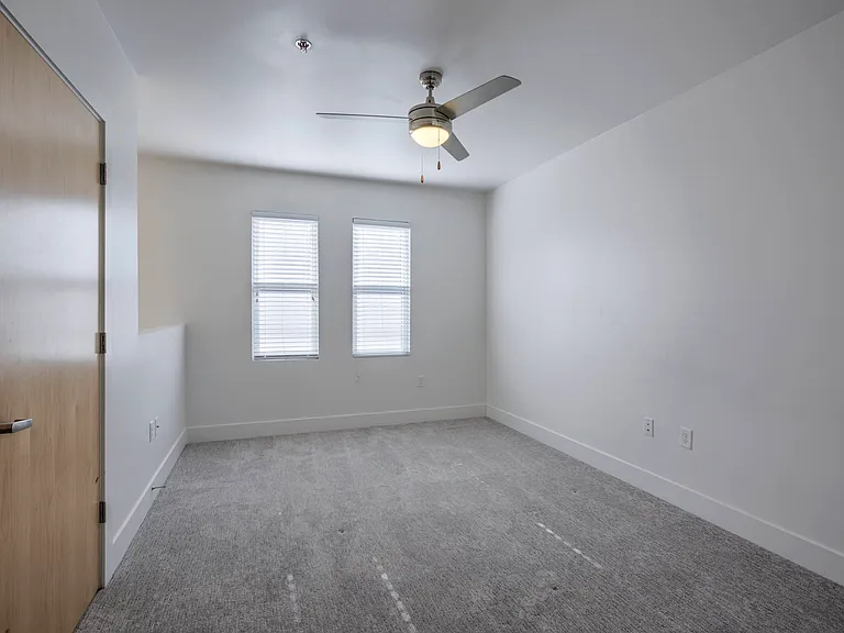 Large bedroom with a ceiling fan at The Sawyer.