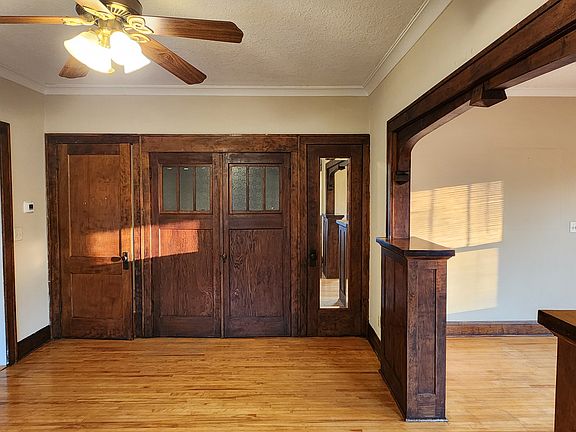 View of dining room wall with doors closed. Coat closet has 100 year old mirror. Walk in storage closet (center) has original glass. Evening sun filtering through the LR windows.