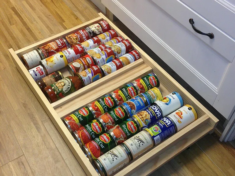 Custom "toe kick" drawers for organizing cans and jars.
