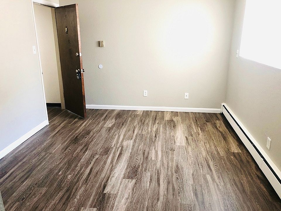 Inviting room with elegant wood flooring, abundant natural light, and freshly painted walls, perfect for a cozy living space.