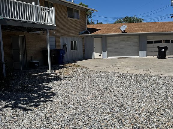 Back of house with 2 -car garage, view of upstairs deck, & basement walk out entry.