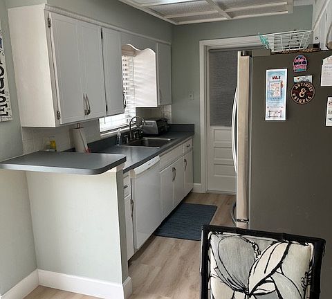 Galley kitchen with skylight and access to the laundry and spare refrigerator that are located in the garage.