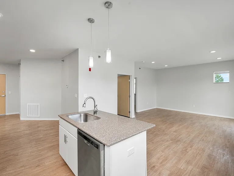 Spacious open-concept living area with modern kitchen, featuring sleek countertops and elegant lighting. Spacious open-concept living area with modern kitchen, featuring sleek countertops and elegant lighting.