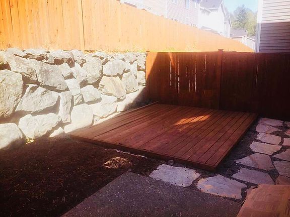 There is a large backyard with a tall fence.